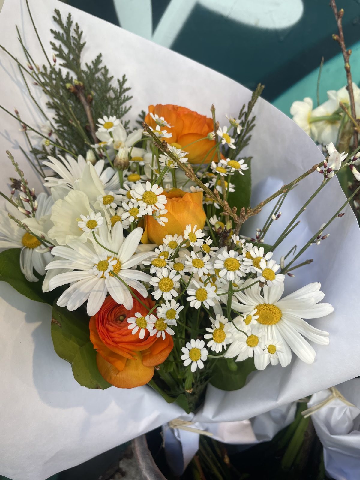 Bouquet de marguerites, renoncules orange et feuillages